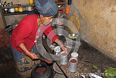 A woman prepares Tongba aka Nepali Beer from fermented millet in a guest house in Bhedetar Editorial Stock Photo