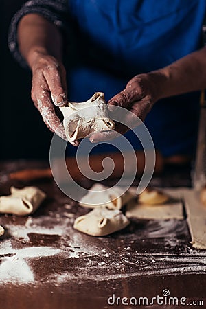 A woman is preparing buns from puff pastry oaking apple envelopes puff pastry cakesn a table in a bakery Stock Photo