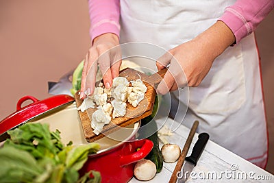Woman preparing cauliflower for cooking Stock Photo