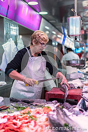 Woman preparing fish on a stall in the central market of Valencia `Mercado Central` Editorial Stock Photo