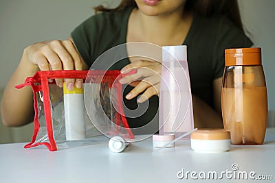 Woman preparing travel kit for transporting cosmetics on airplane Stock Photo