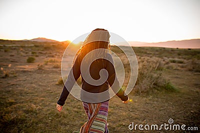 Woman in a pristine landscape during a beautiful blazing sunset Stock Photo