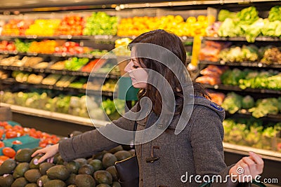 Woman in the produce section of a grocery store. Stock Photo