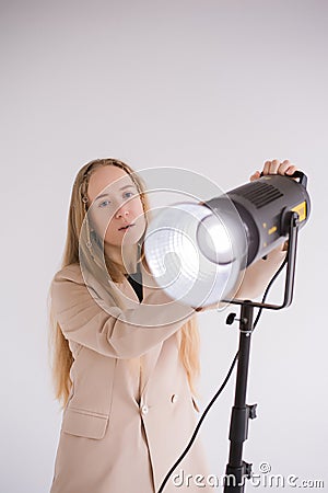 Woman Professional gaffer adjusts constant light Stock Photo