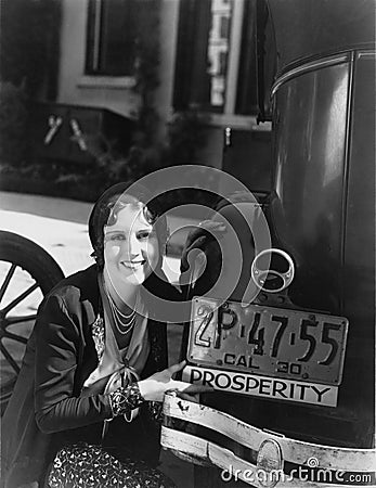 Woman with prosperity sign on car bumper Stock Photo