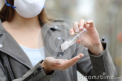 Woman with protective mask sanitizing hands Stock Photo