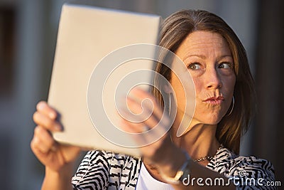 Woman Puckering Lips at Tablet Stock Photo