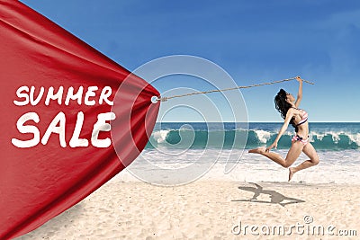 Woman pulling a banner of summer sale Stock Photo