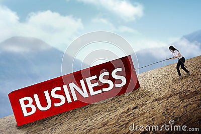 Woman pulling block with business type Stock Photo