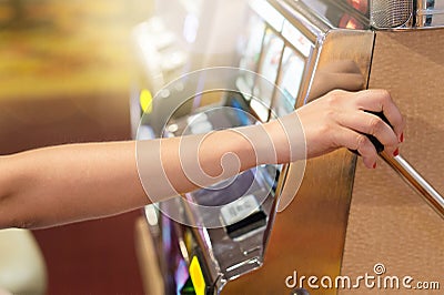 Woman pulling the handle on a slot machine in a casino. Stock Photo