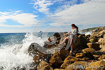 Woman pulls another girl from the sea after a shipwreck Stock Photo