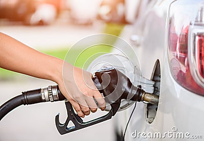 Woman pumping gasoline fuel in car at gas station. Stock Photo