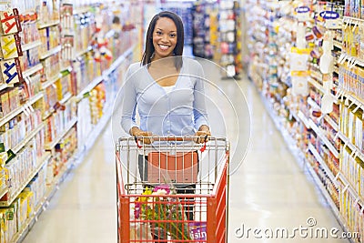 Woman pushing trolley in supermarket Stock Photo