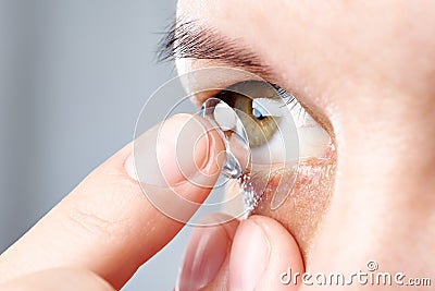 Woman puts contact lens Stock Photo