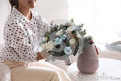 Woman putting beautiful wedding winter bouquet in vase at home, closeup Stock Photo