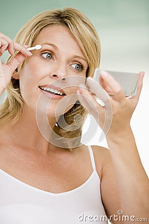 Woman putting on eye make up Stock Photo