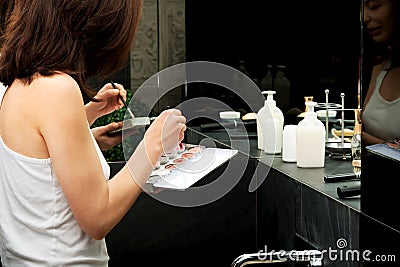 Woman putting on eye make up. Stock Photo