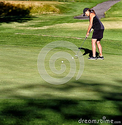 A woman on the putting green at a golf tournament Editorial Stock Photo