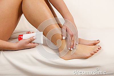 Woman putting ointment on bad ankle applying cream Stock Photo