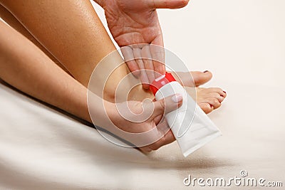 Woman putting ointment on bad ankle applying cream Stock Photo