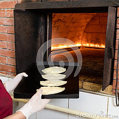 Woman putting qutab meal to the oven Stock Photo