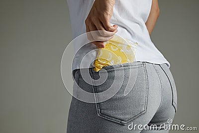 Woman putting sanitary pad into jeans pocket Stock Photo