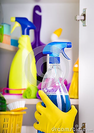 Woman putting spray bottle in pantry Stock Photo