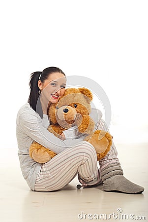 Woman in pyjama hugging bear Stock Photo