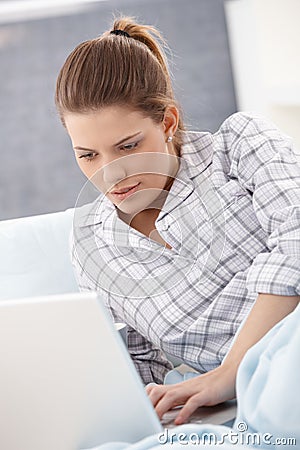 Woman in pyjama using laptop Stock Photo