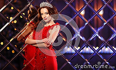 Woman queen princess in crown and lux dress, lights party background Luxury girl Long shiny healthy volume hair Waves Curls Stock Photo