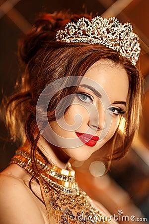 Woman queen princess in crown and lux dress, lights party background Luxury girl Long shiny healthy volume hair Waves Curls Stock Photo