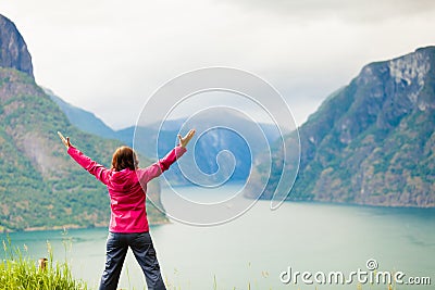 Woman with raised hands in norwegian mountains fjords Stock Photo