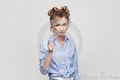 Woman raising index finger, looking with angry expression, warning you about danger. Stock Photo