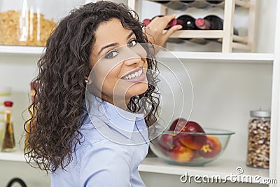 Woman Reaching for Bottle of Red Wine on Rack Stock Photo