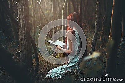 Woman reading alone in the woods Stock Photo