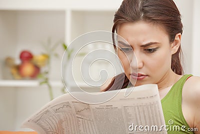 Woman reading bad news in newspaper Stock Photo