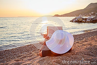 Woman reading a book on the beach Stock Photo