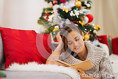 Woman reading book near Christmas tree Stock Photo