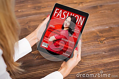 Woman reading fashion magazine on tablet Stock Photo