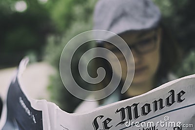 Woman reading french newspaper, Le Monde Editorial Stock Photo