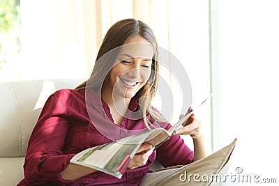 Woman reading a magazine at home Stock Photo