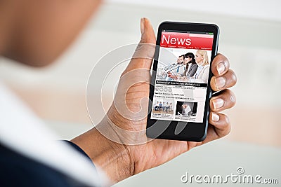 Woman Reading News On Mobile Phone Stock Photo