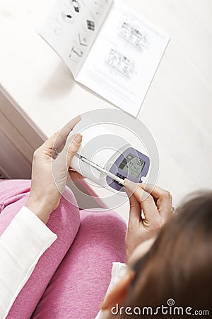 Woman reading ovulation test kit Stock Photo