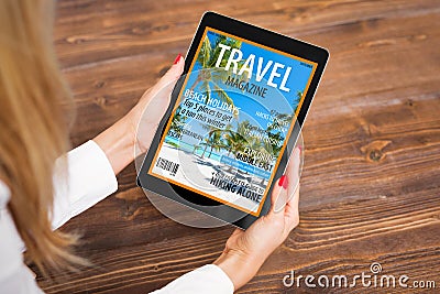 Woman reading travel magazine on tablet Stock Photo