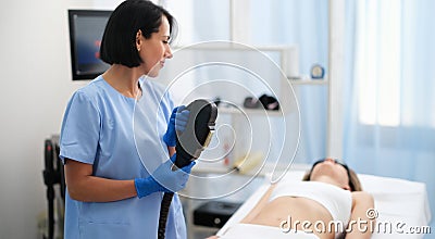 Woman receives treatment with aesthetic dermatological device Stock Photo