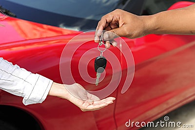 Woman receiving car key from salesman Stock Photo