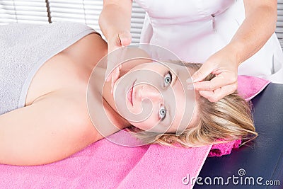 Woman receiving facial acupuncture treatment on young attractive girl Stock Photo