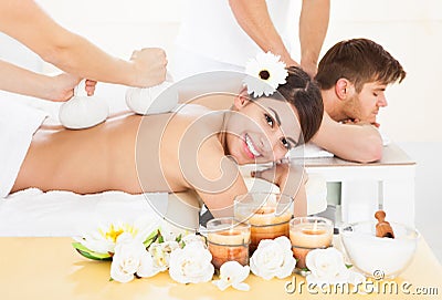 Woman receiving massage with herbal compress stamps Stock Photo