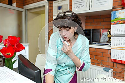 Woman receptionist in veterinary clinic talking on phone with customer Editorial Stock Photo