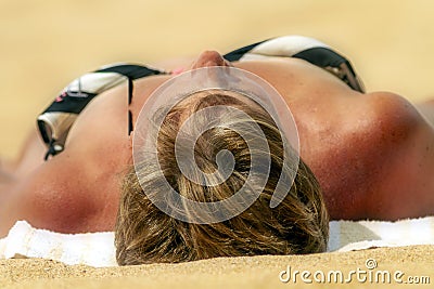 Woman Reclining Sun Tanning on a Tropical Beach Stock Photo